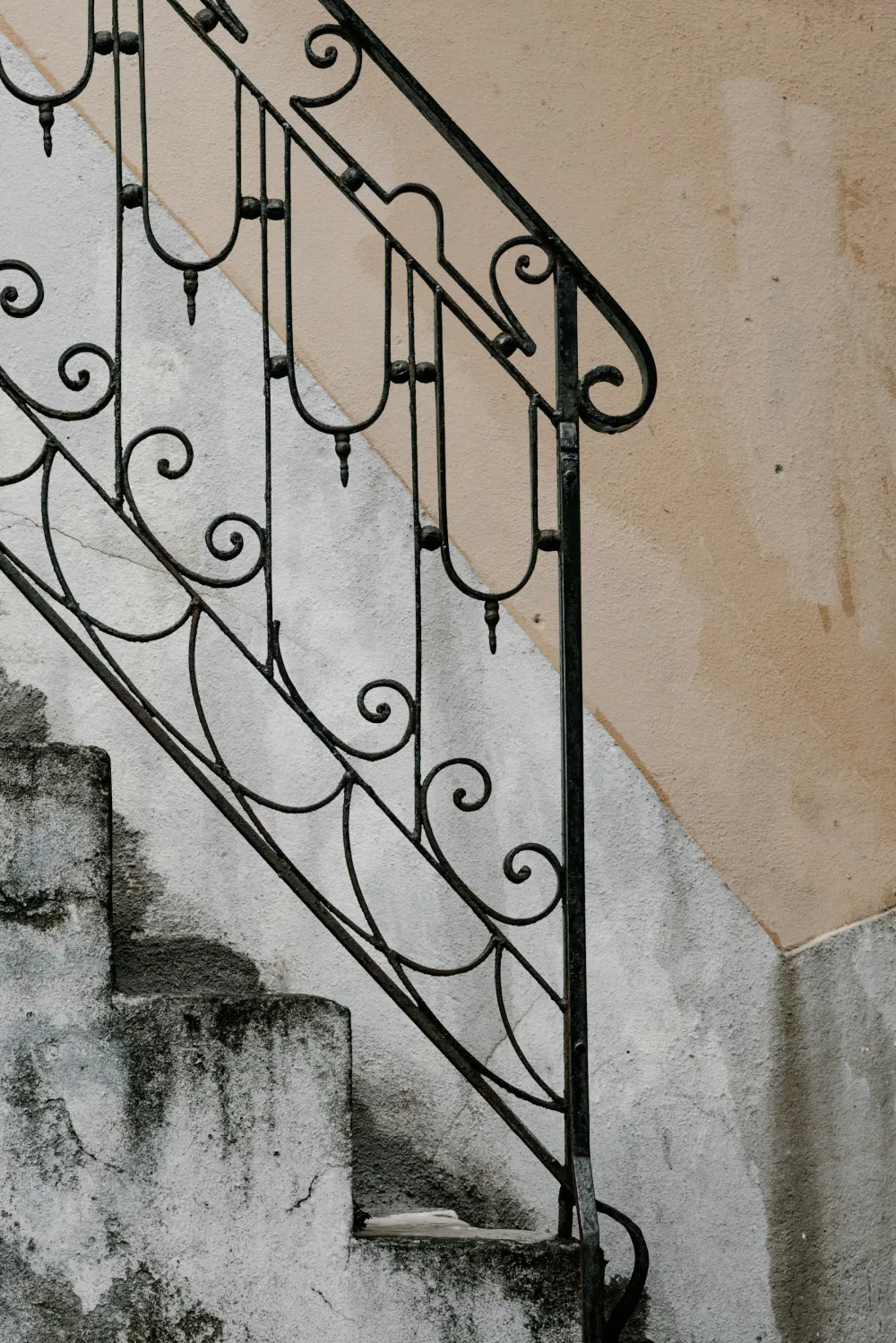 Black-painted cast-iron railings with scrolled detail on a stone staircase