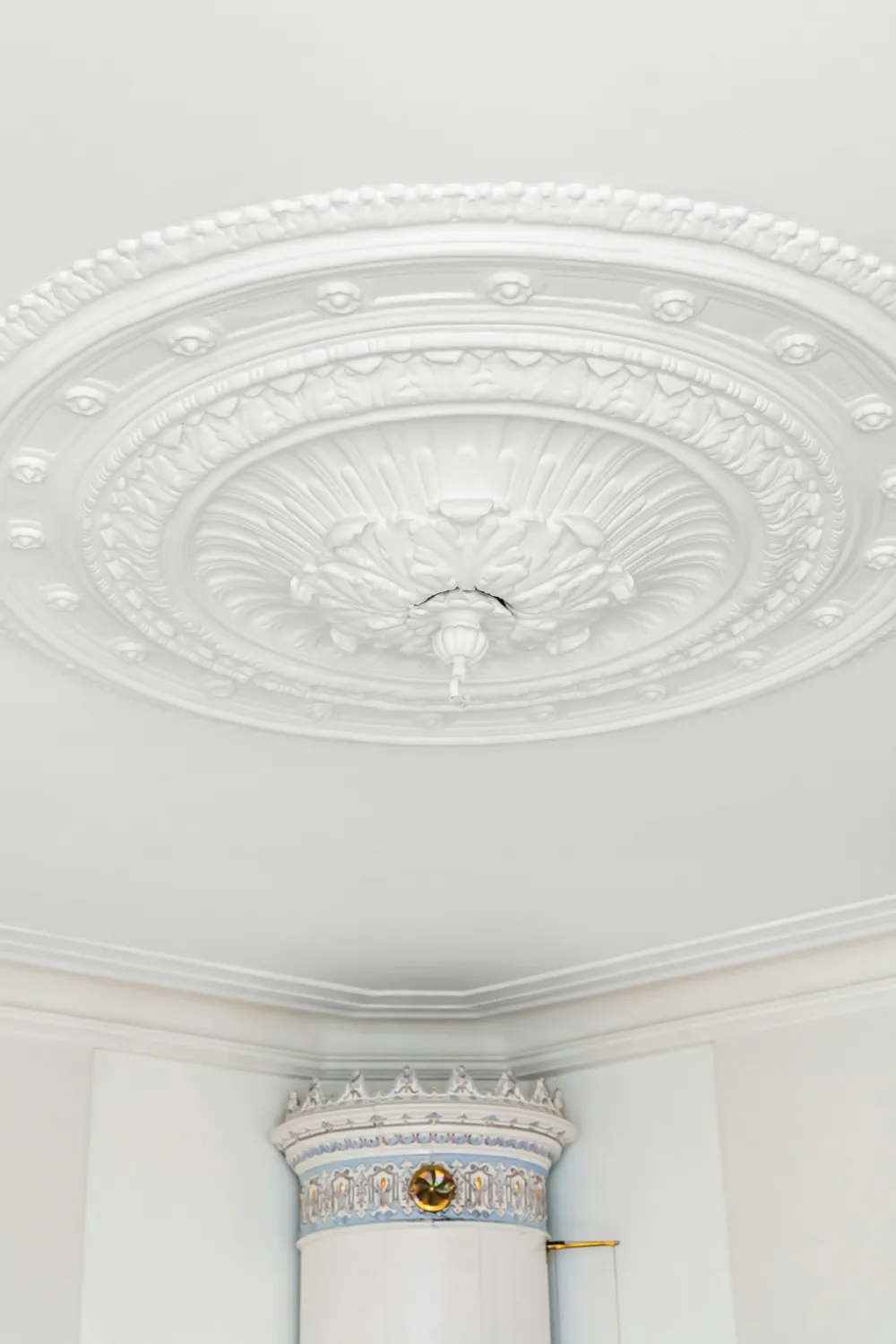A freshly painted white ceiling with a plaster rose and cornice above tall windows