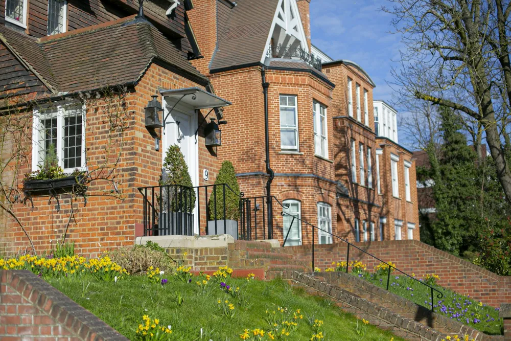 Edwardian red-brick houses with white-painted windows and gables on a London street