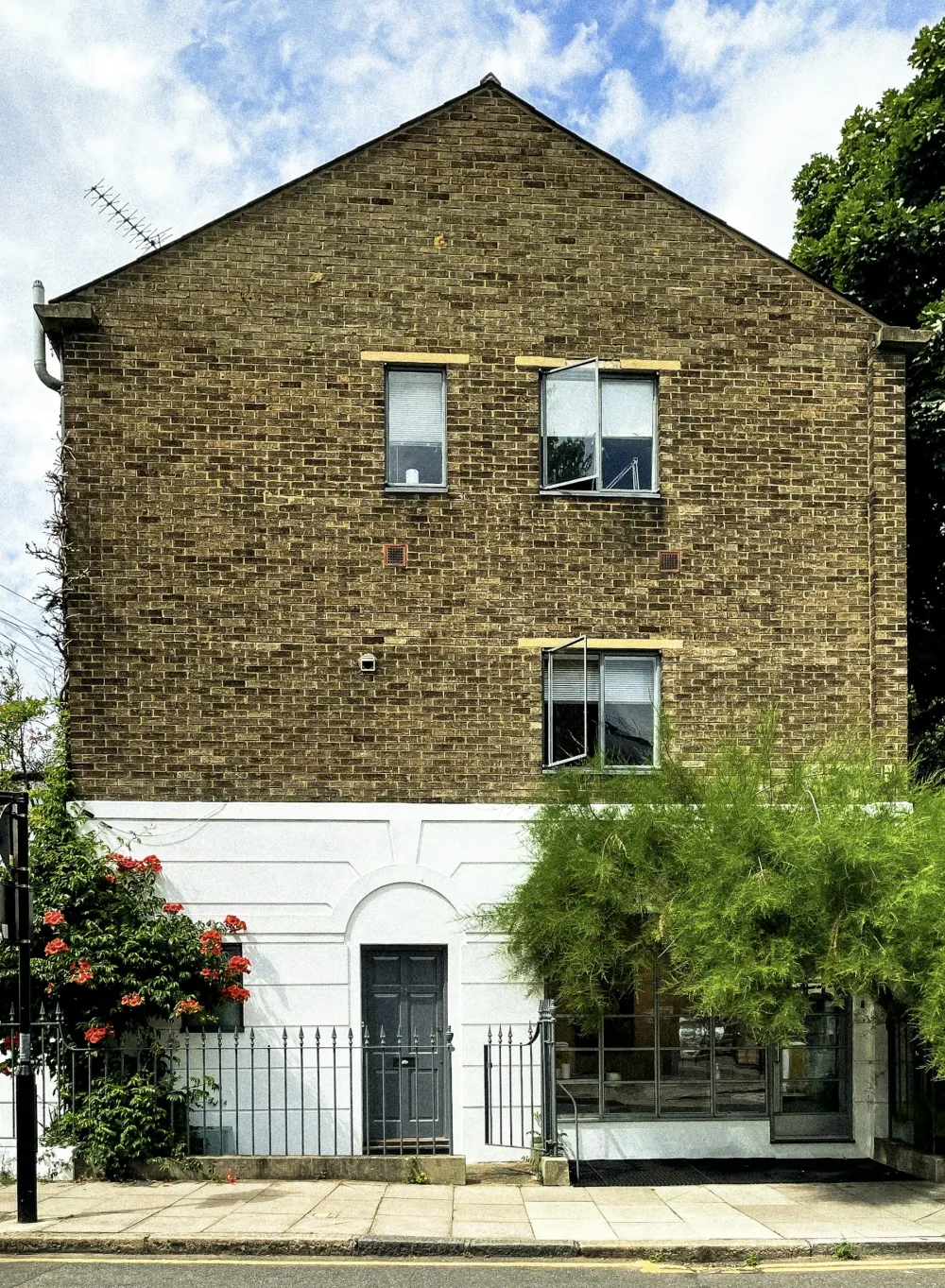 A London house with a painted white rendered ground floor beneath yellow stock brick